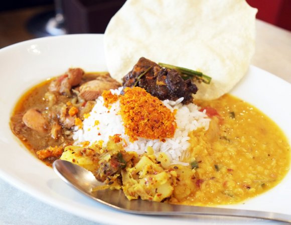 白い皿に2種類のカレーとつけ合わせ、インド風おせんべいが盛られているスリランカワンプレートランチ